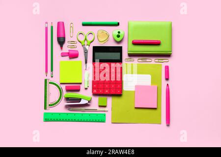 Modern calculator with different stationery on pink background Stock Photo