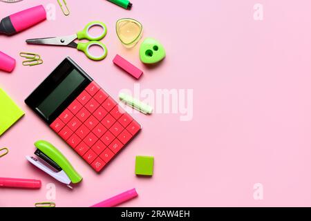 Modern calculator with different stationery on pink background Stock Photo