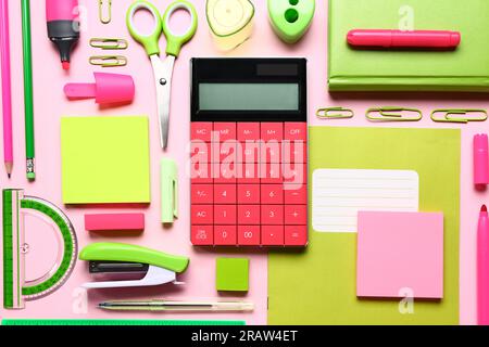 Modern calculator with different stationery on pink background Stock Photo