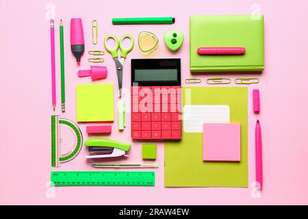 Modern calculator with different stationery on pink background Stock Photo