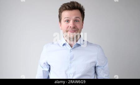 The young European man confidently looks into the camera and smiles Stock Photo