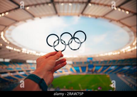 PARIS, FRANCE, JULY 7, 2023: Athlete Holds Olympic Rings Symbol with Pride. Photo for Summer Olympic Games in Paris 2024. Stock Photo