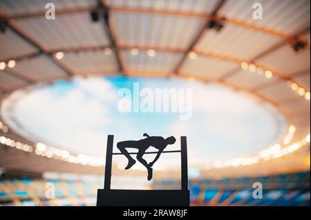 Silhouette of High Jumper Inspiring at Modern Stadium. Photo for Summer Games 2024 in Paris. Edit Space for Your Montage. Stock Photo