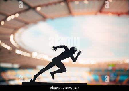 Sprinting through Dusk: Silhouette of a Male Athlete, a Long-Distance Runner, Resiliently Pursuing Excellence at a Modern Sports Stadium Stock Photo