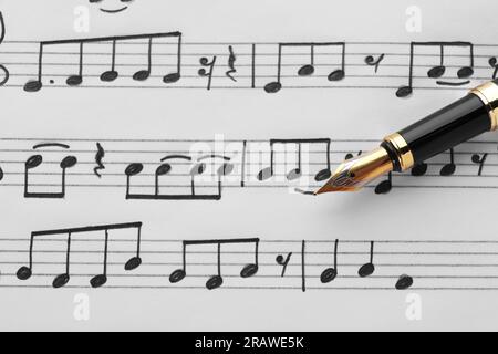 Sheet with musical notes and fountain pen, closeup view Stock Photo