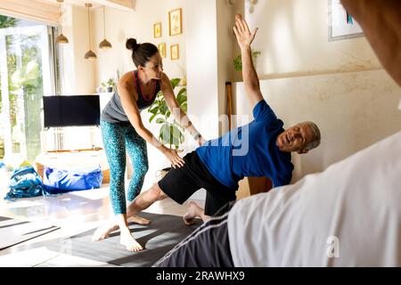 Senior diverse people with caucasian female teacher exercising in pilates class. Exercise, retirement, wellbeing and healthy senior lifestyle, unalter Stock Photo