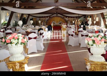 France : organisation de mariage, décoration de salle pour le diner des invités, le tapis rouge traverse la salle jusqu'au podium Stock Photo