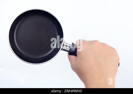 close up of male hand holding a small frying pan isolated on white background Stock Photo