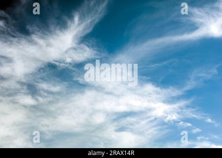 Nature background of wispy cirrocumulus clouds against a blue sky. Stock Photo