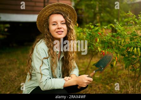 Pretty female gardener taking care of her lovely garden on a lovely ...