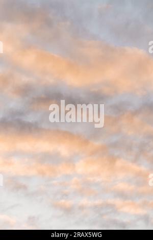As the sun sets on the horizon, the clouds are painted with hues of orange, pink, and purple, creating a stunning and display in the evening sky. Stock Photo
