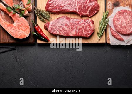 Various raw meat and fish. Steaks, burgers, salmon and spices. Flat lay with copy space Stock Photo