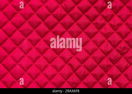 red stitched quilted bag cloth background closeup Stock Photo