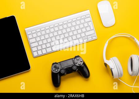 Gaming gear and tech accessories on a yellow background, perfect for gaming and tech-related themes. Flat lay Stock Photo
