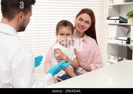 Children's hepatitis vaccination. Mother with her daughter and doctor in clinic Stock Photo