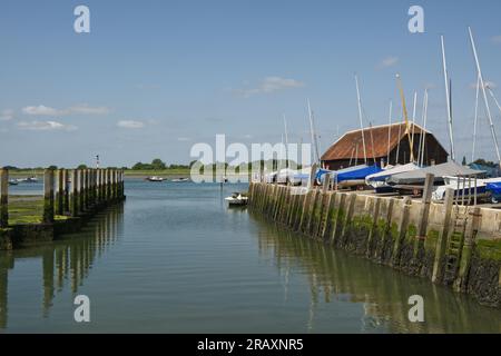 Harbour side at Bosham Quay in Chichester Harbour, West Sussex, England. With moored boats and low tide. Stock Photo