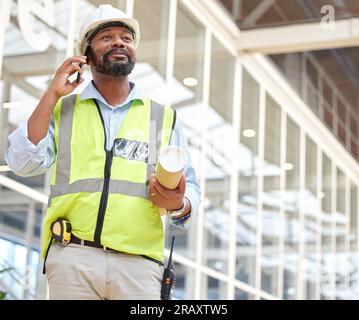 Phone call, black man and architect with blueprint, talking and planning to work on construction project. African engineer, mobile technology and Stock Photo