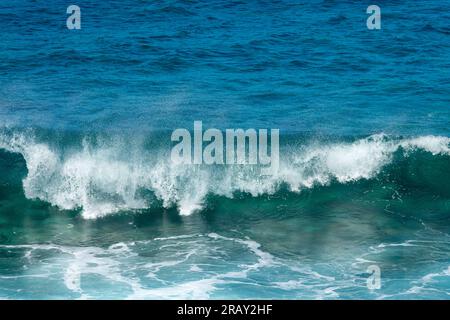 Front view of a crashing wave. Blue clear transparent water splash, ocean background. Stock Photo