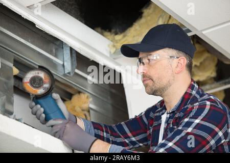 workman using angle grinder on metal Stock Photo