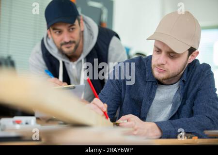 carpenter with apprentice in training period Stock Photo