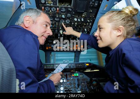 two modern aircraft engineers in cockpit Stock Photo