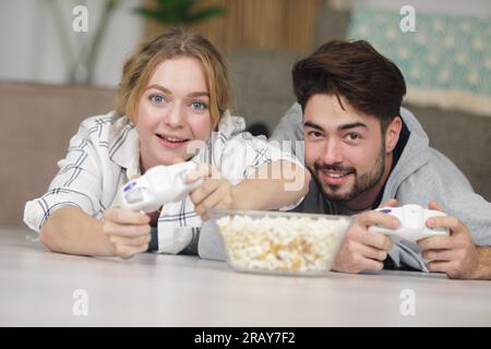 young friends play video games together at home Stock Photo