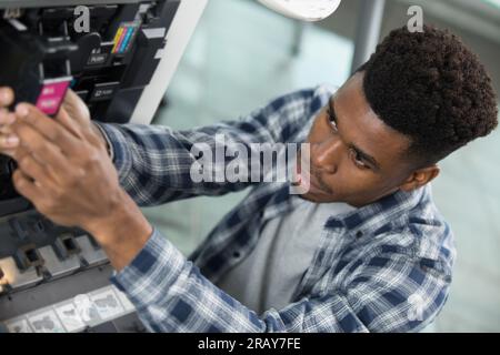 technician is checking and changing the printer equipment cartridges Stock Photo