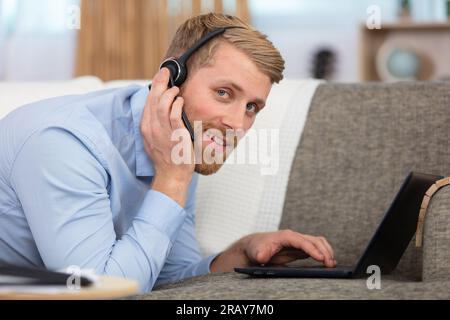 man sitting at home enjoying studying using laptop Stock Photo