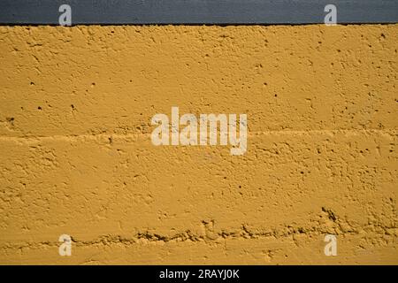 Close up of a yellow cement wall with cracks and crevices for grounge background of urban or social themes Stock Photo