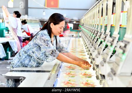 Caoxian, China's Shandong Province. 6th July, 2023. A staff member works at a Hanfu factory in Caoxian County, east China's Shandong Province, July 6, 2023. Caoxian County has developed a complete Hanfu industrial chain in recent years. At present, there are more than 2,100 Hanfu-related enterprises in the county. The sales of Hanfu in Caoxian reached nearly 4 billion yuan (about 552 million U.S. dollars) in the first half of this year. Credit: Guo Xulei/Xinhua/Alamy Live News Stock Photo