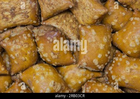 Pretzel nuggets scattered loosely, closeup macro image. Savory pastry snack traditionally made in Germany and France. Stock Photo