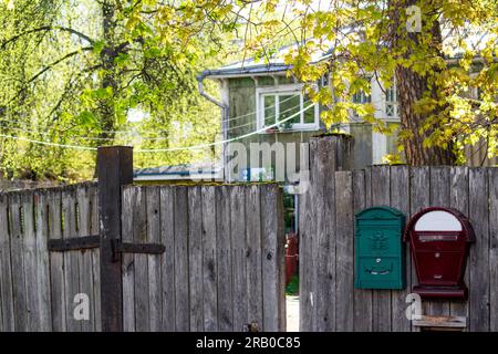 Mailboxes on the fence of a private house in the countryside, a cozy suburban area Stock Photo