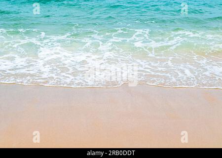 Soft blue ocean wave on clean sandy beach. Copy space. Stock Photo