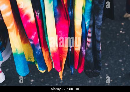 Array of colorful unisex tie-dye shirts. Selective focus. Closeup. Stock Photo