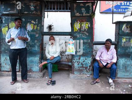 Indian men sit in front of old telecom cabinets in old Delhi, Delhi, New Delhi, India Stock Photo