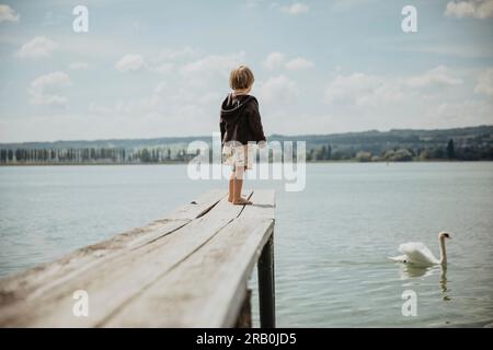 Little boy on a jetty by the lake Stock Photo