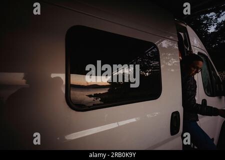 Woman gets out of door from camper Stock Photo