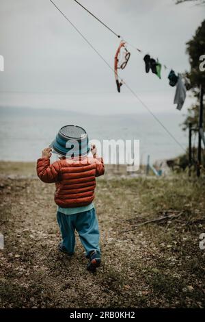 Little girl playing with a bowl on her head Stock Photo