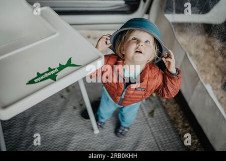 Little girl playing with a bowl on her head Stock Photo