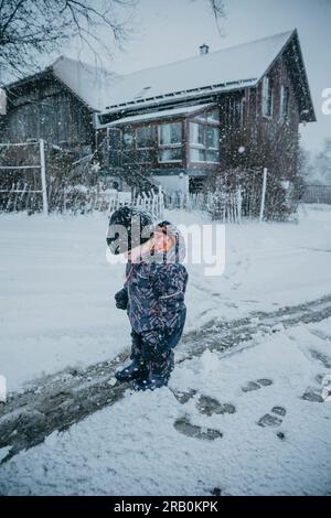 Little girl makes footprints in snow Stock Photo