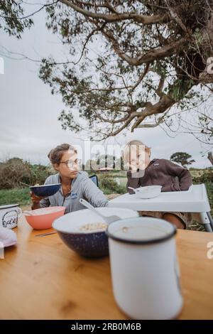 Mother and son having breakfast at a campsite Stock Photo