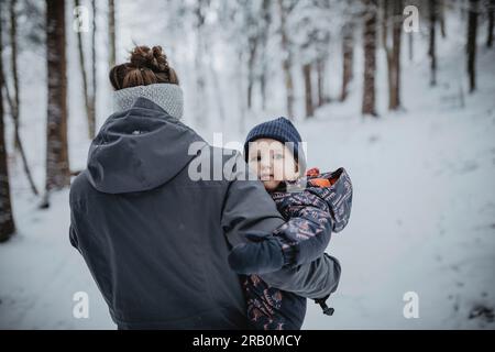 Little girl with winter clothes going through deep snow in park