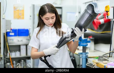 Technician holding prosthetic limb checking and working in laboratory Stock Photo