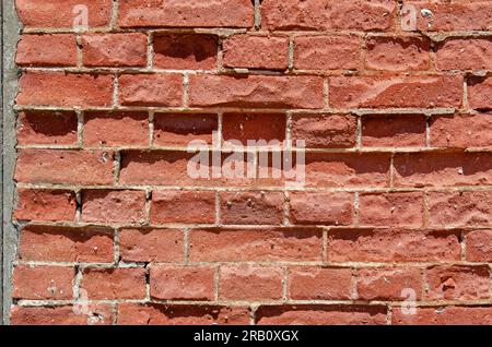 Old and damaged wall with red bricks and light grey mortar Stock Photo
