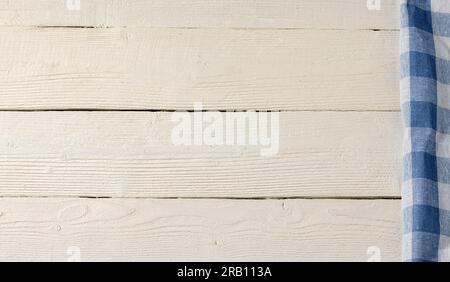 White wooden background with a blue checkered napkin.Copy space. Stock Photo