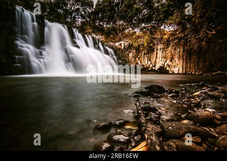 Beautiful waterfall falling over basalt stelae, long exposure in the forest of Rochester Falls, Mauritius Stock Photo