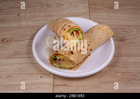 Felafel & Hummus Wrap in white plate on wooden background Stock Photo