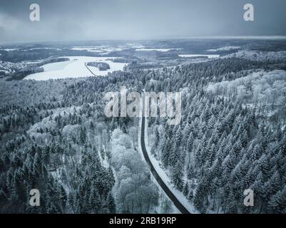 Road through the forest in winter, Swabian Alb, Baden-Württemberg, Germany Stock Photo