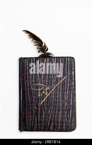 Folded vintage poetry album with a feather as a bookmark Stock Photo