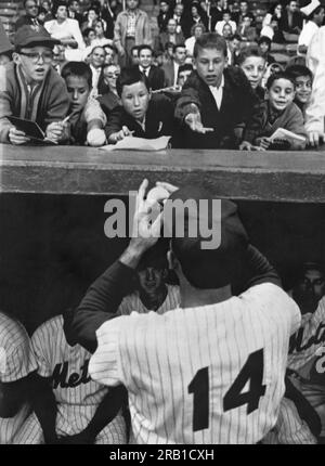 New York, New York:  August 25, 1962 New York Mets first baseman Gil Hodges tantalizes youg fans with the promise of an autographed baseball as they lean over the dugout on Gil Hodges Night in a game against the Los Angeles Dodgers. Stock Photo